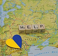 Landkarte der Urkraine mit der Landesflagge als Herz und dem Wort Help