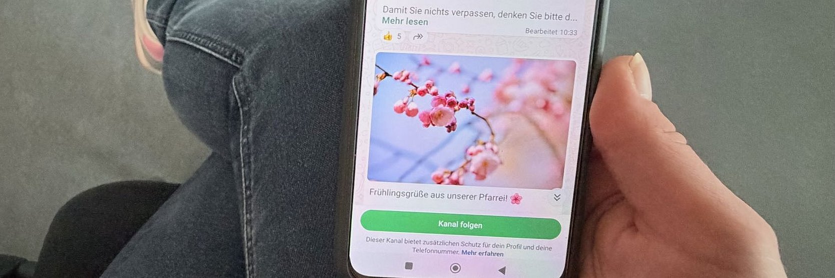 Eine Person liest den WhatsApp Kanal der Pfarrei 