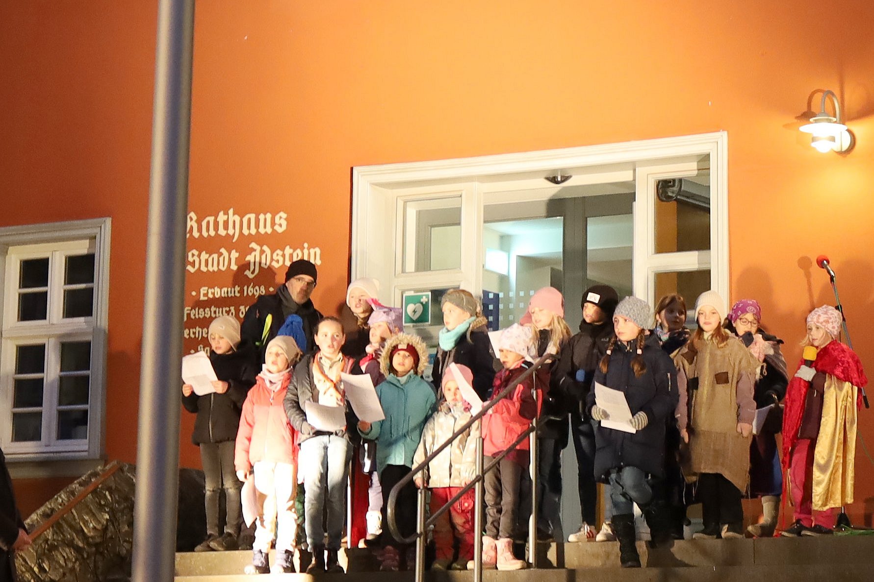 Der Bischof lauscht dem Lied der Kinder aus der Pfarrei St. Martin Idsteiner Land.