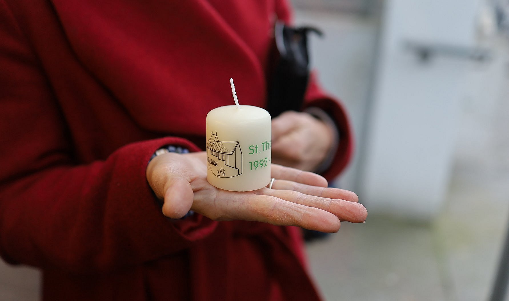 Eine Hand hält die Gedenkkerze