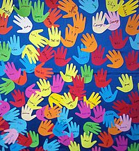 ausgeschnittene bunte Papier-Kinderhände mit Namen