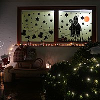 Mit dem Nikolaus und Weihnachtssymbolen beklebtes Adventsfenster.
