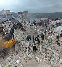 Zerstörte Häuser und im Vordergrund steht ein Bagger