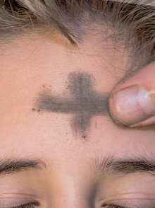 Plakat auf dem eine Stirn gerade das Aschekreuz gezeichnet bekommt.
