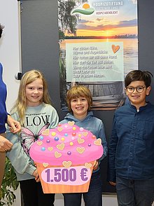 Die Erstkommunionkinder Maya, Diego, Konrad und Isabella (von rechts) überreichen Dorothea Ahlers (links) den großen Spendenmuffin.  