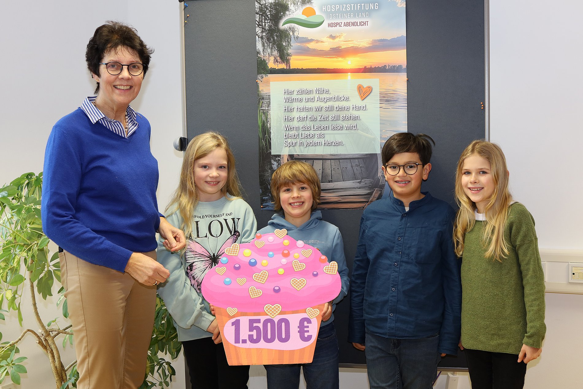Die Erstkommunionkinder Maya, Diego, Konrad und Isabella (von rechts) überreichen Dorothea Ahlers (links) den großen Spendenmuffin.  