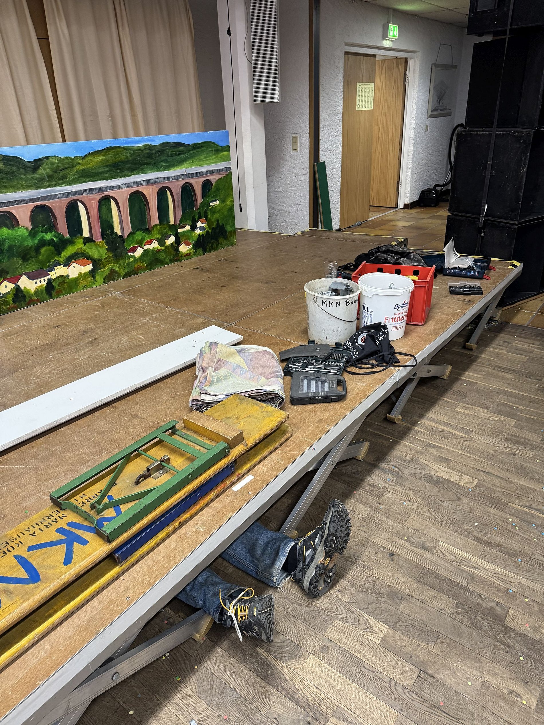 Ein Helfer liegt unter der abzubauenden Tribüne und schraubt. 