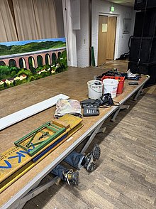 Ein Helfer liegt unter der abzubauenden Tribüne und schraubt. 