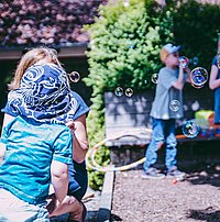 Kinder spielen mit Seifenblasen