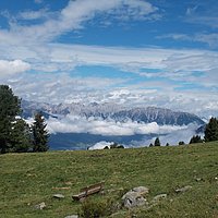 Wiese mit einer Ruhebank und Bergblick