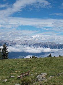 Wiese mit einer Ruhebank und Bergblick